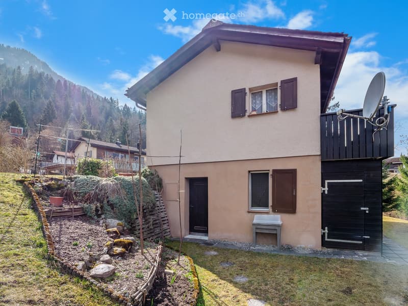 2 story house, beige exterior, brown shutters, satellite dish, garden, garage