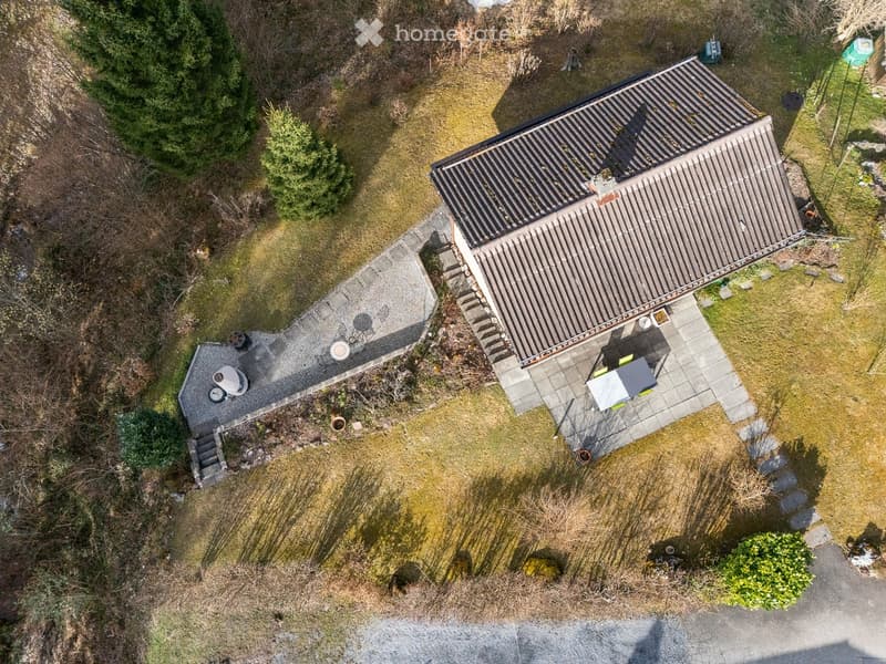 Detached house, brown roof, paved driveway, outdoor seating area, garden, terrace
