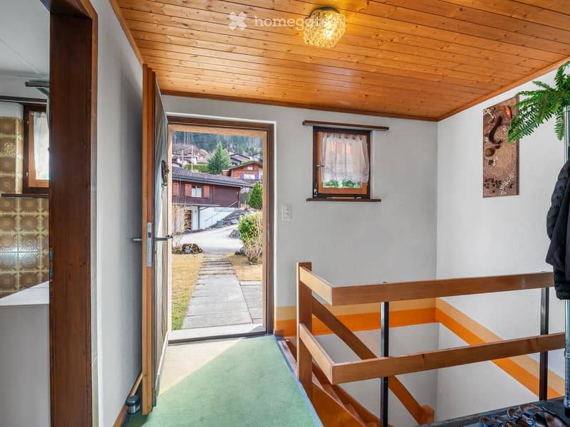 wooden ceiling, open door, green carpet, wooden handrail, white wall, small window, outdoor view