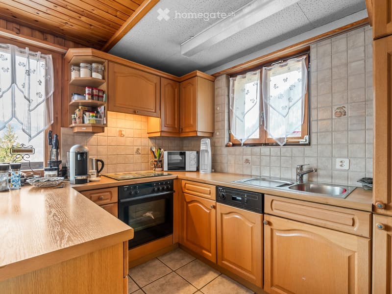 Wooden cabinets, tiled floor, stainless steel sink, dishwasher, microwave, coffee maker, electric stove, wooden countertop