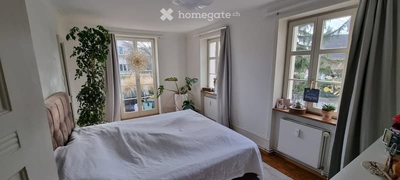 double bed, large windows, plants, radiator