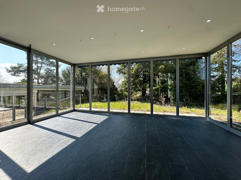 large glass windows, black tiled floor, bright sunlight, outdoor view