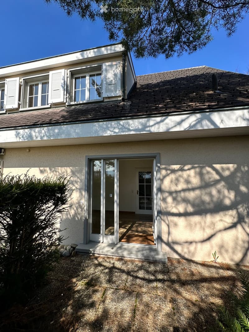 white exterior, brown roof, white shutters, glass sliding door, small porch, gravel pathway