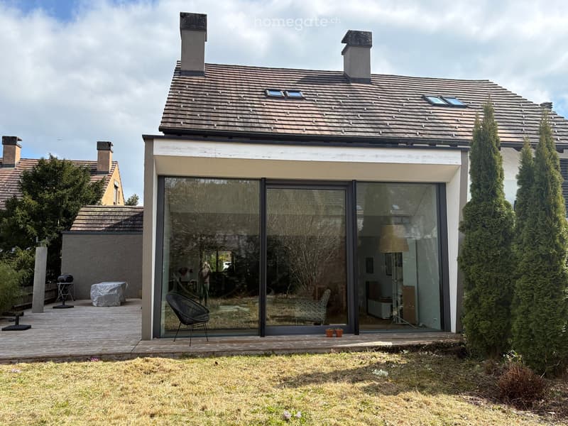 modern house, brown roof, glass walls, wooden deck, outdoor seating, chimneys