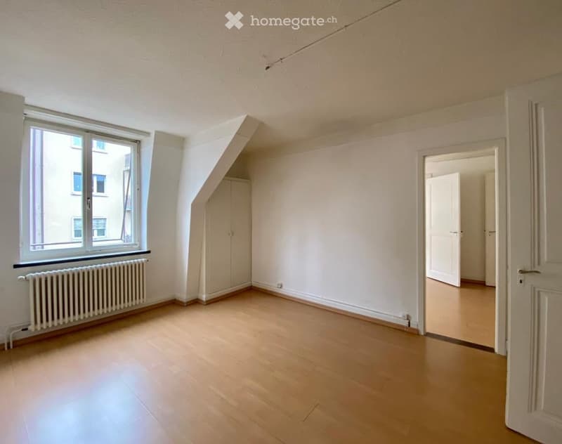 empty room, wooden floor, white walls, large window, white radiator, two doors