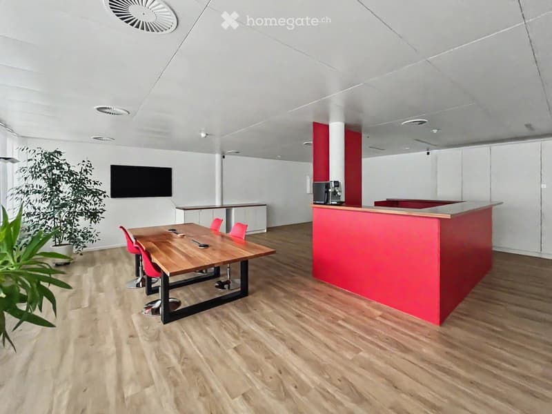 modern office room with wooden floor, red and white walls, wooden table, red chairs, microwave, television