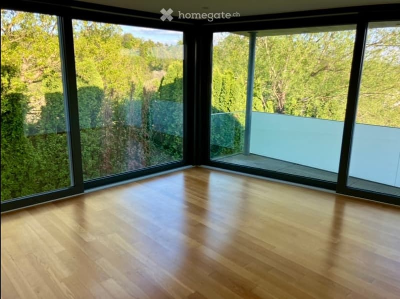 large windows, wooden floor, balcony, view of trees