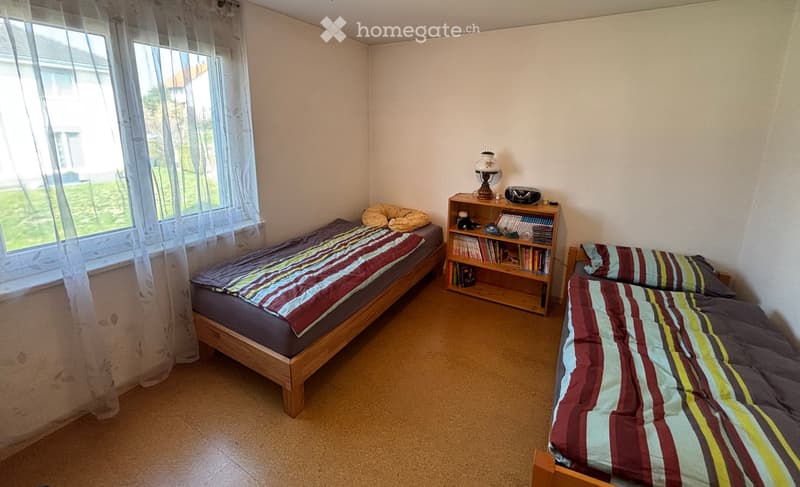 small bedroom with two beds and window