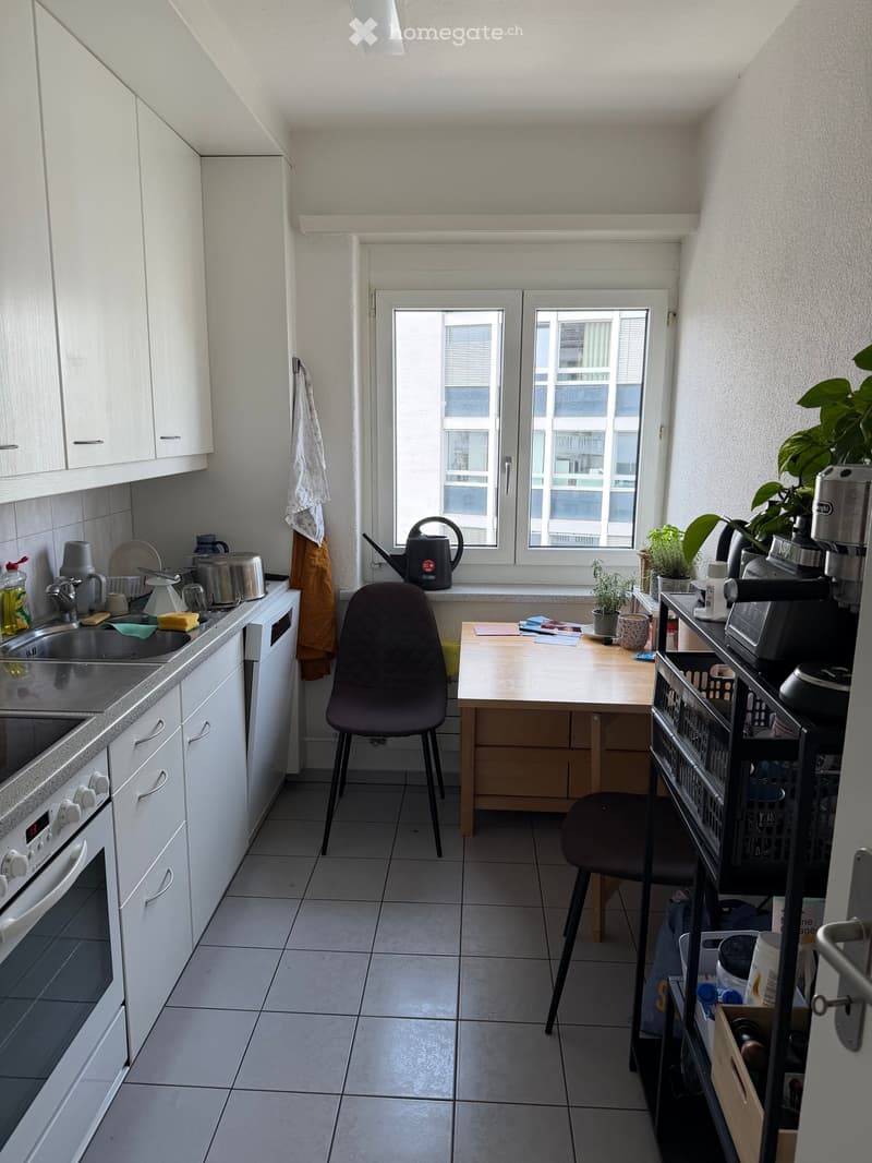 modern kitchen with white cabinets, tiled floor, sink, oven, window with view