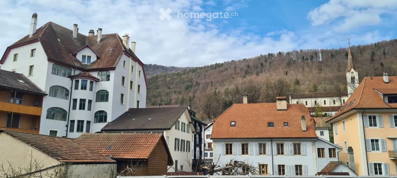 Multiple houses, brown roofs, white walls, mountain in the background