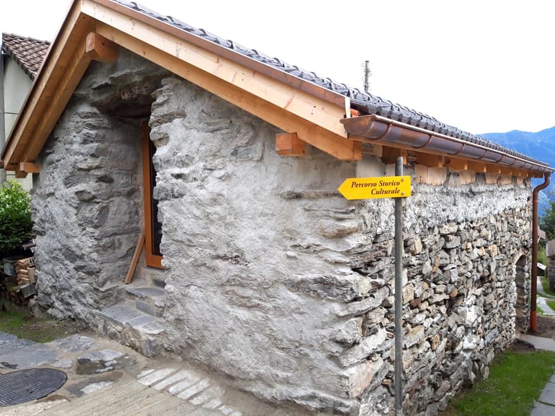 Stone house with wooden roof, wooden door, stone walls, signboard