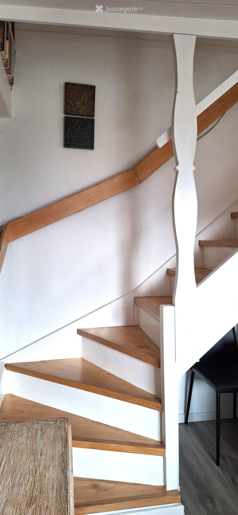 wooden stairs, white painted wall, wooden handrail, black chair, wooden table