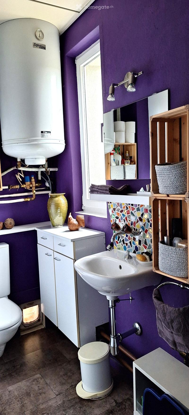 Purple walls, white sink, white toilet, white cabinets, wooden shelves, white water heater, tiled floor