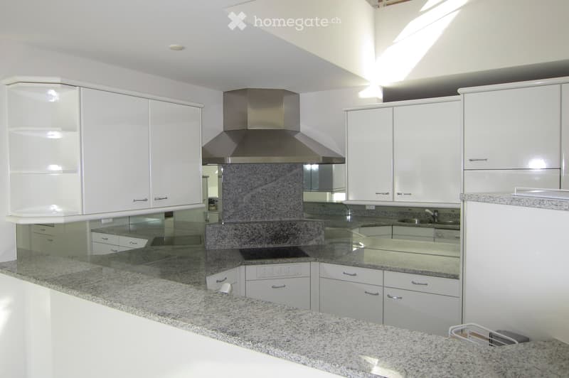 modern kitchen with granite countertops, white cabinets, stainless steel appliances, and a large window