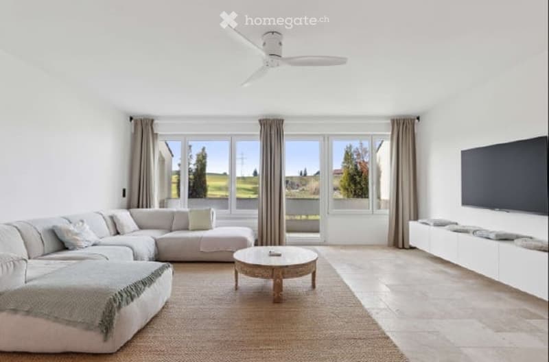 modern living room, white walls, large windows, white sectional sofa, coffee table, ceiling fan, flat screen TV