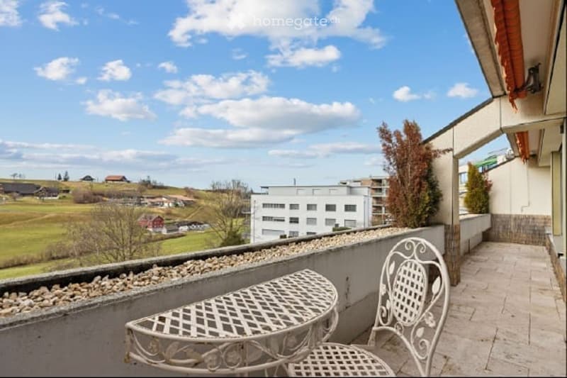 Balcony with table and chairs, gravel border, view of the landscape