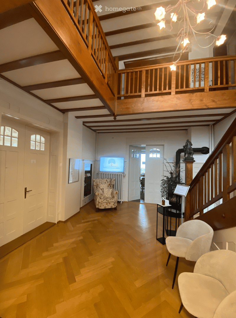 wooden floor, white walls, wooden balcony, chandelier, white doors, white chairs, radiator, TV, picture frame, statue