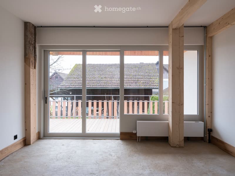 empty room, large glass sliding doors, balcony, wooden beams, white walls