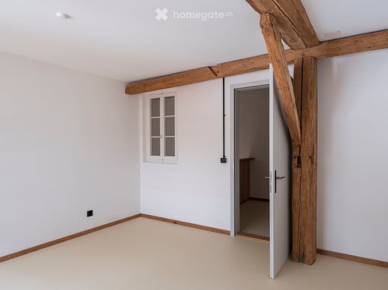 empty room, white walls, wooden beams, wooden floor, open door, small window