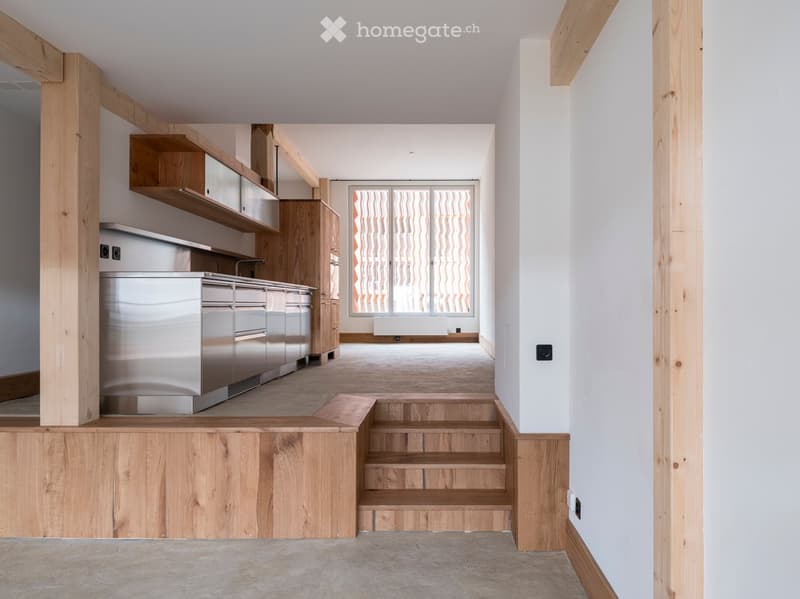 modern kitchen with stainless steel appliances, wooden cabinets, wooden beams, white walls, large window