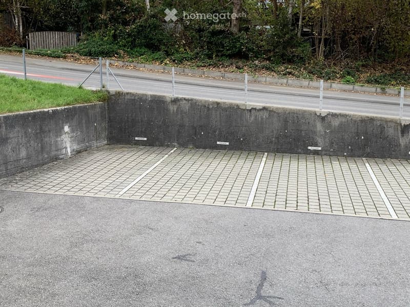 Empty parking lot with brick flooring, concrete walls, and metal poles