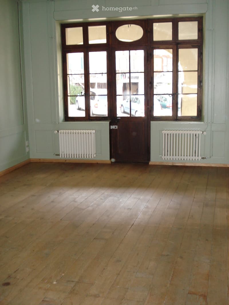 empty room, wooden floor, white walls, wooden door, large windows, radiators