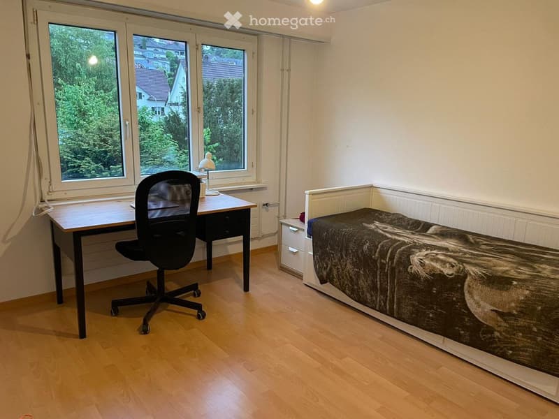 Empty bedroom with desk and office chair, white cabinet and single bed.