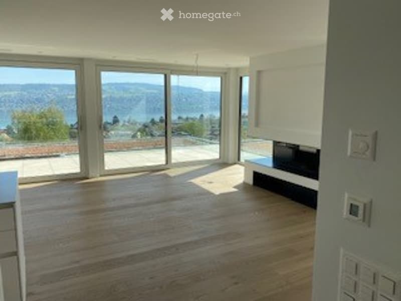 large windows, wooden floor, fireplace, view of the lake