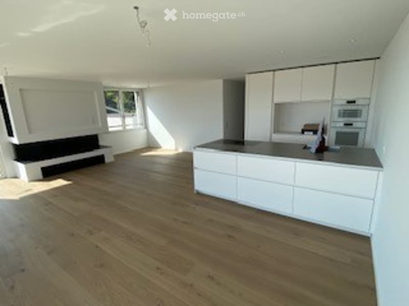 Empty kitchen with white cabinets, wooden floor, large windows, built-in oven and microwave