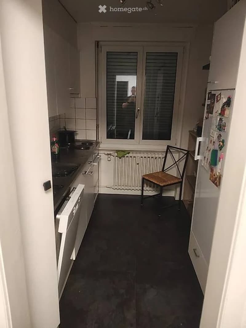 kitchen with white cabinets, black countertops, white refrigerator, white chair, white radiator, window with blinds