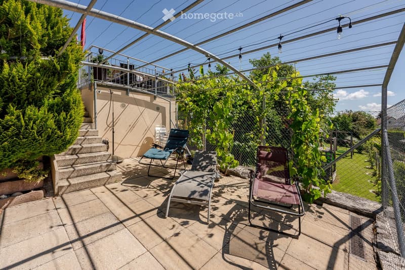 covered terrace with metal frame, lounge chairs, plants, stairs, metal fence