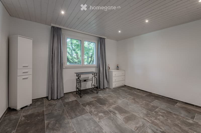 empty room, white walls, gray tiled floor, white cabinet, small table, window with curtains