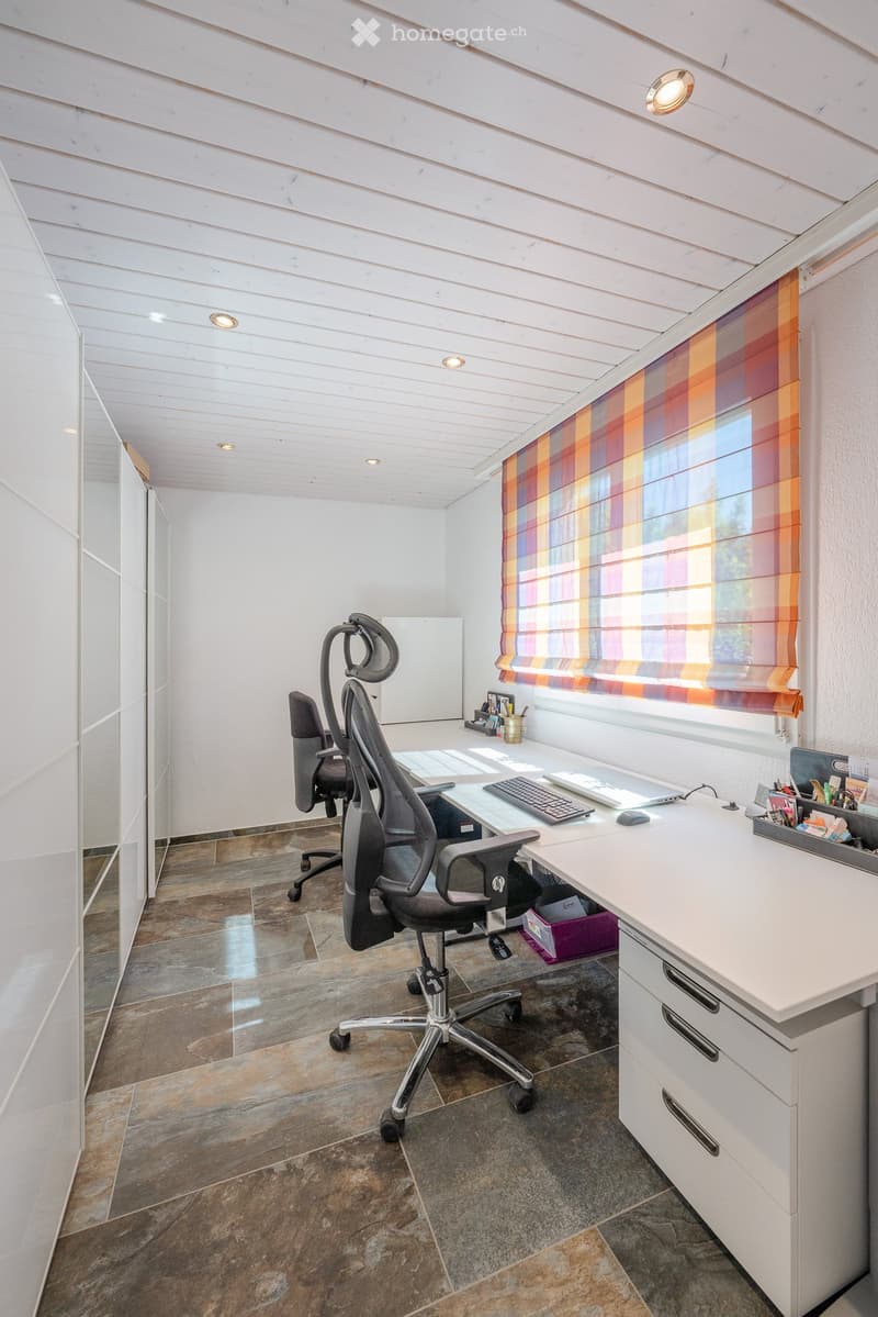 modern office room with white walls, white desk, two office chairs, white cabinets, white ceiling, tiled floor, window with striped curtain