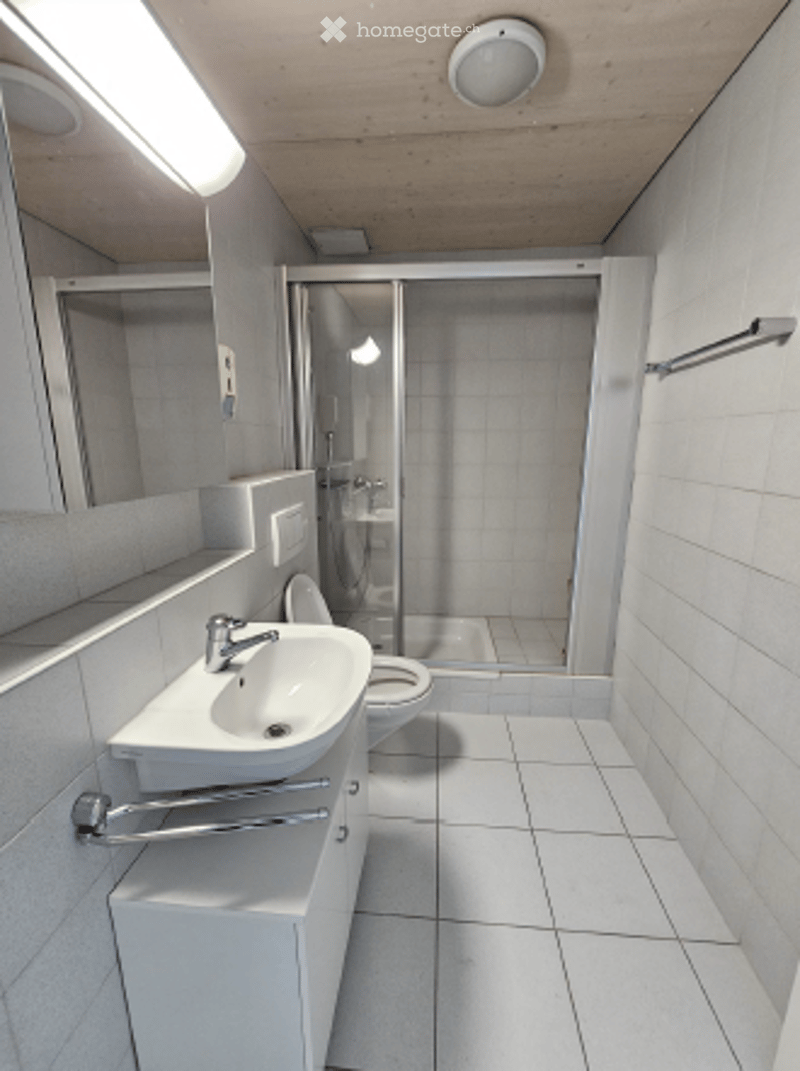 white tiled floor, white sink, white toilet, shower stall, mirror, white cabinet