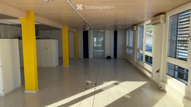 empty room, wooden floor, yellow pillars, white cabinets, large windows