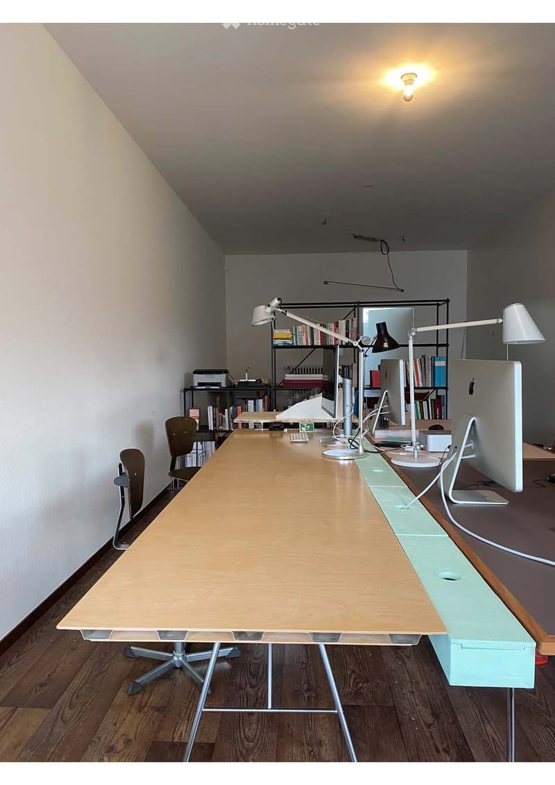 large desk, office chairs, bookshelves, computer monitors, lamps, printer, wooden floor