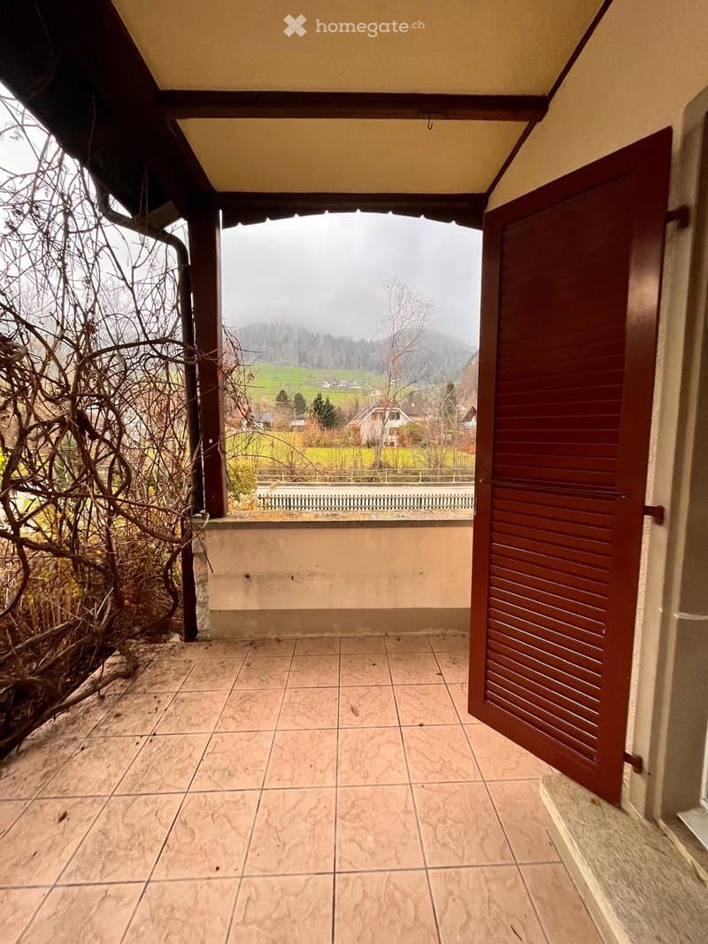 tiled floor, wooden door, balcony, view of mountains and fields