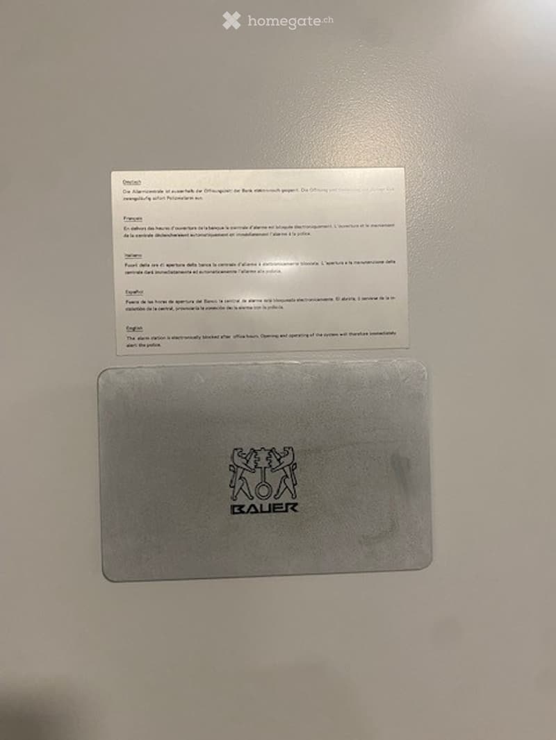 A white paper with black text and a silver card with the word 'BAUER' on it