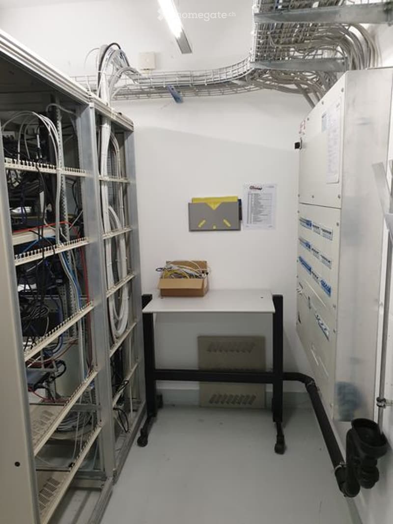 server room with metal cabinets, wires, boxes, and a desk