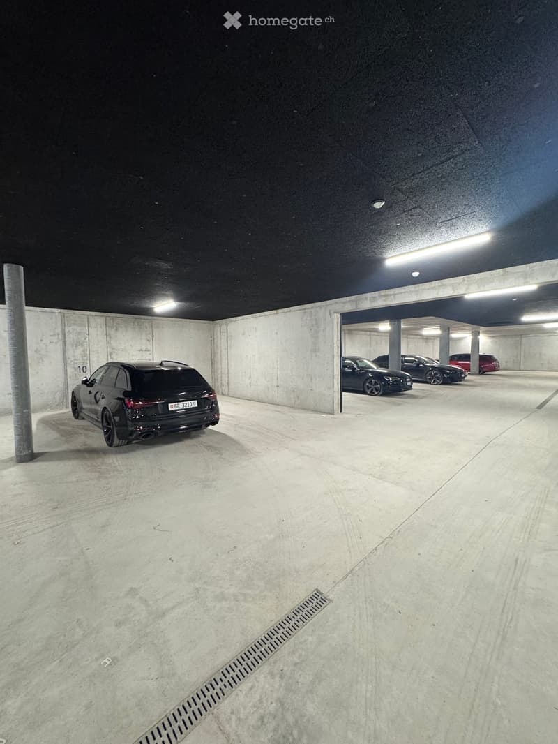 underground parking lot, concrete walls, 4 cars parked, number 10 on the wall