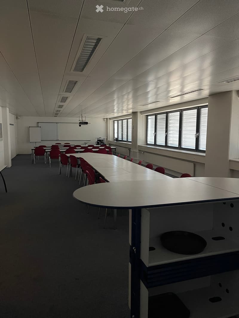 empty classroom with long tables, chairs, whiteboard, projector