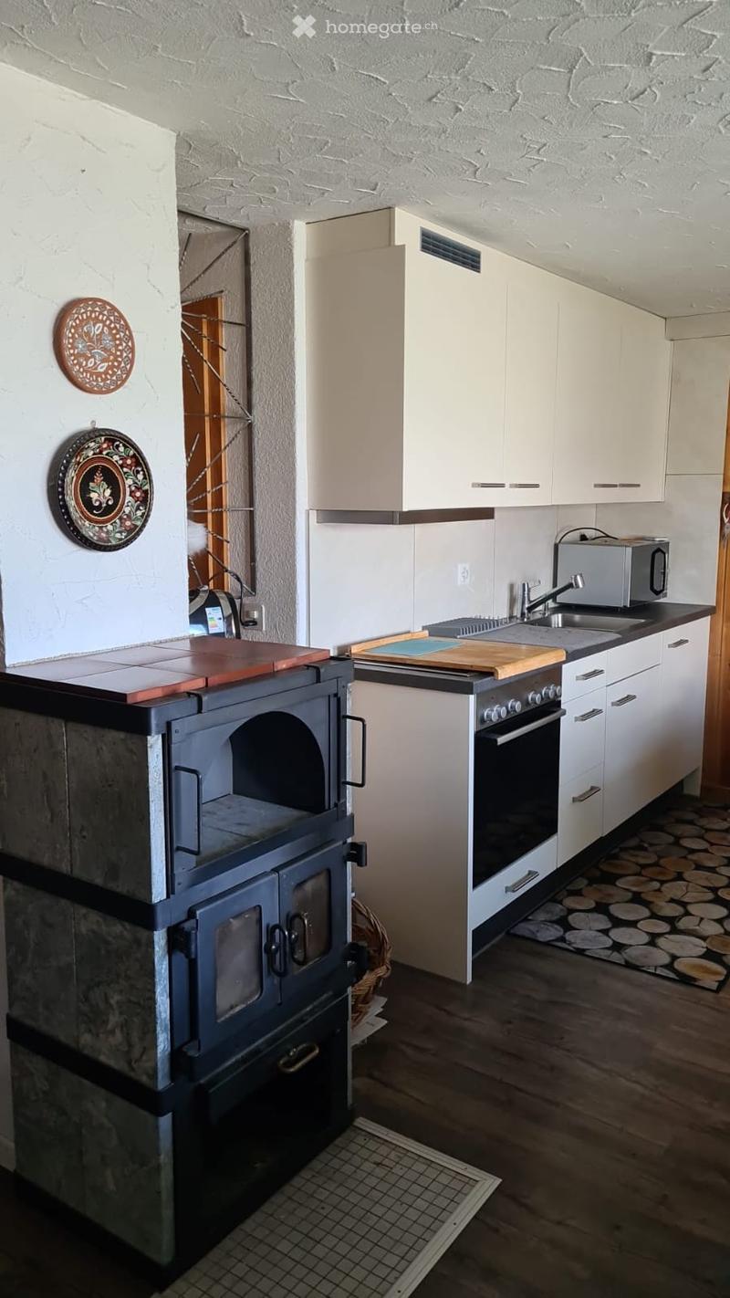 white cabinets, wooden floor, gas stove, oven, microwave, sink, faucet, decorative plates, fireplace