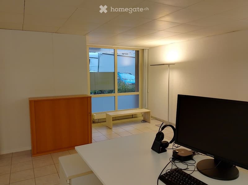empty room, white walls, white desk, computer monitor, keyboard, headphones, bench, window, radiator