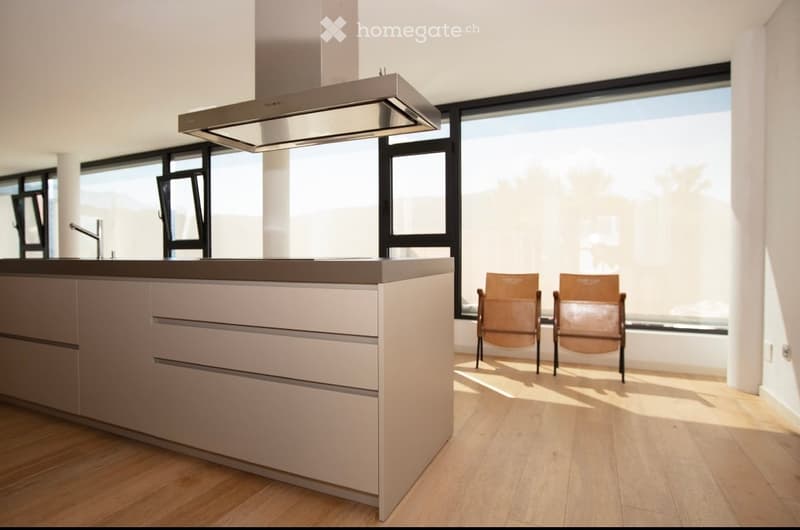 modern kitchen with island, large windows, wooden floor, two chairs, stainless steel range hood, faucet