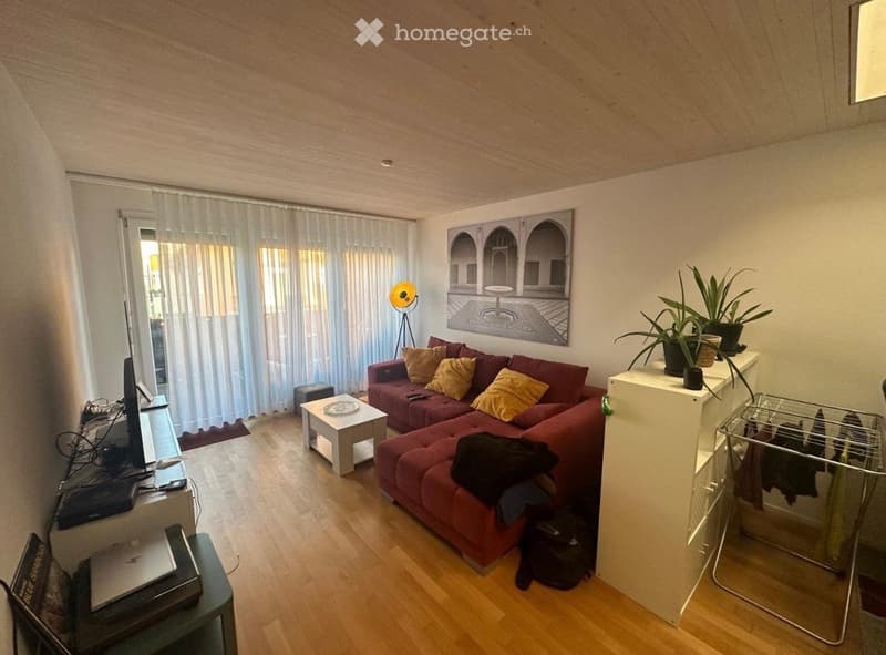 Living room with a red couch, white coffee table, white curtains, a painting on the wall, and a floor lamp