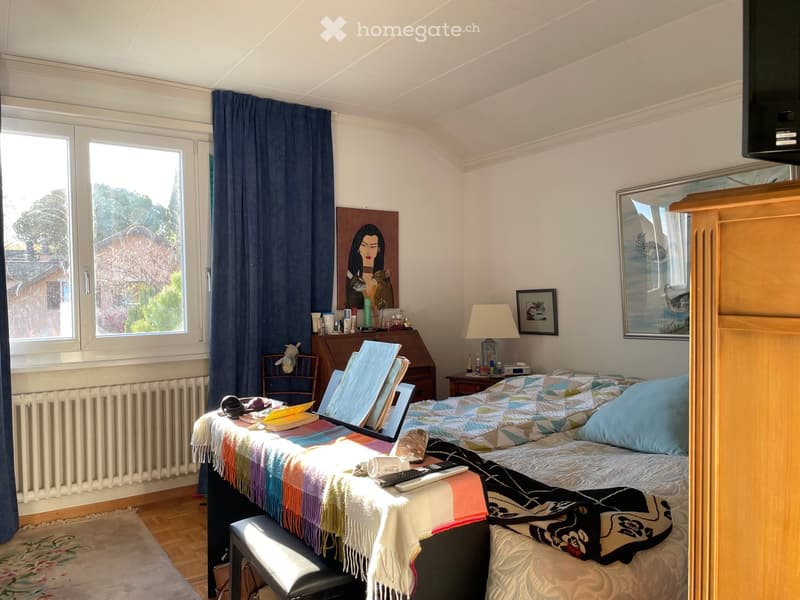 bedroom with bed, desk, chair, radiator, window, curtains, paintings, lamp, cabinet, rug