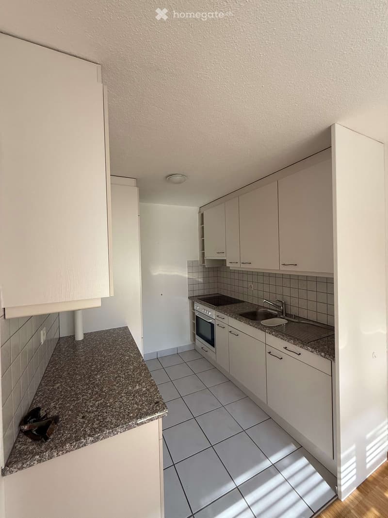 modern kitchen with white cabinets, granite countertops, stainless steel appliances, tiled floor, and a sink with a faucet