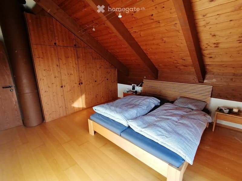 Bedroom with wooden bed, wooden wardrobe, wooden floor, wooden ceiling, nightstands, picture frame, and lamps