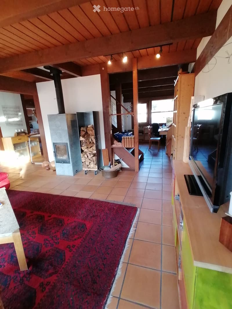 wooden ceiling, fireplace, tiled floor, red carpet, TV, wooden cabinet, wooden table, wooden chair, wooden staircase