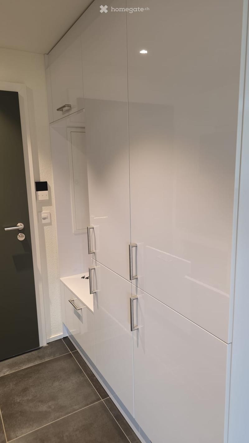 Laundry room with white cabinets, silver handles, tiled floor, sink, and power outlet